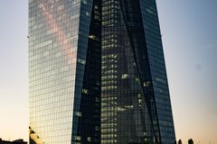 Low-angle shot of the ECB Tower in Frankfurt at sunset capturing an urban skyline.