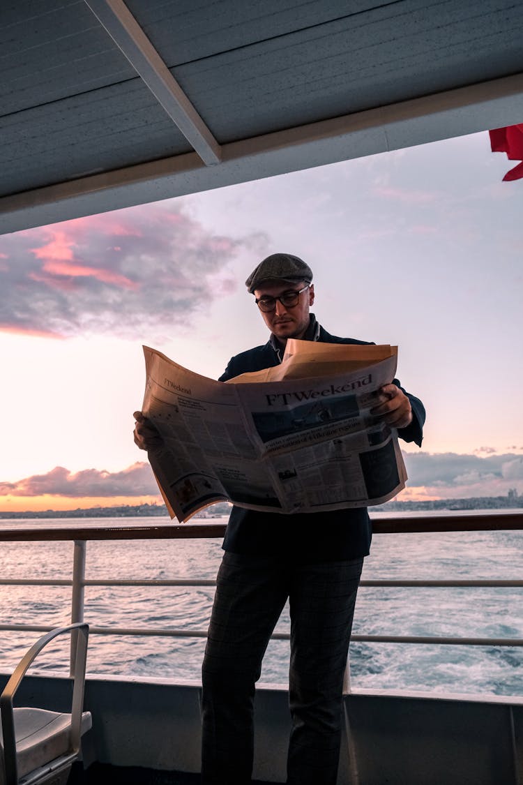 Man Reading Newspaper On Vessel