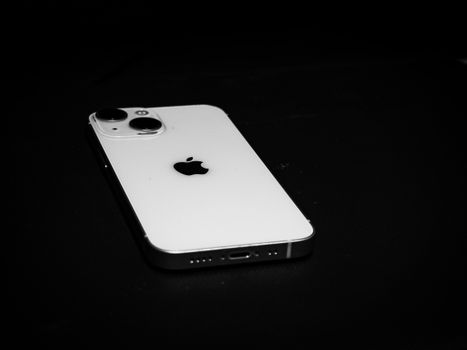 Elegant black and white photo of a smartphone on a dark surface, emphasizing sleek design.