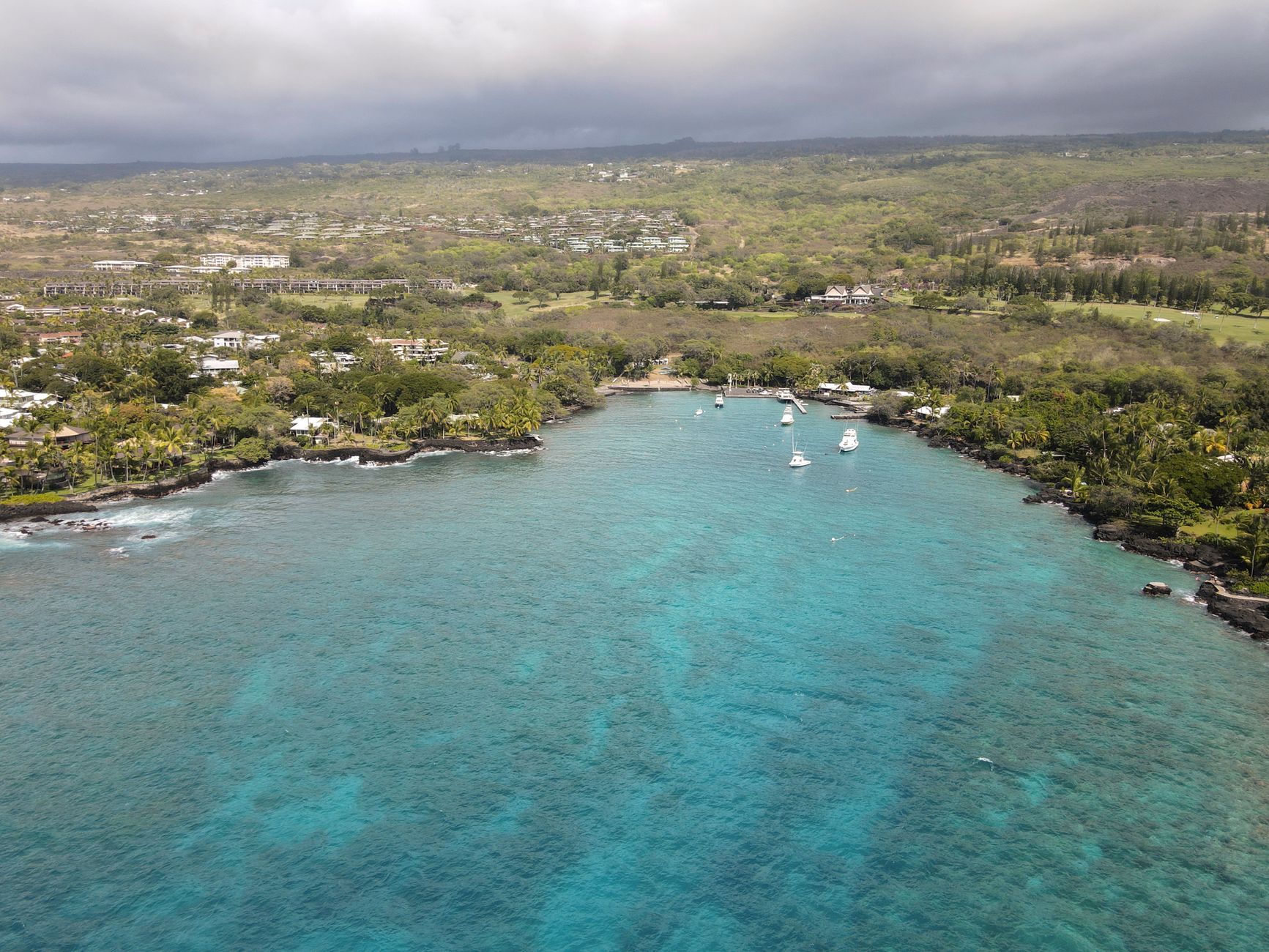 Aerial view of the Kailua-Kona coastline with boats and greenery, Big Island