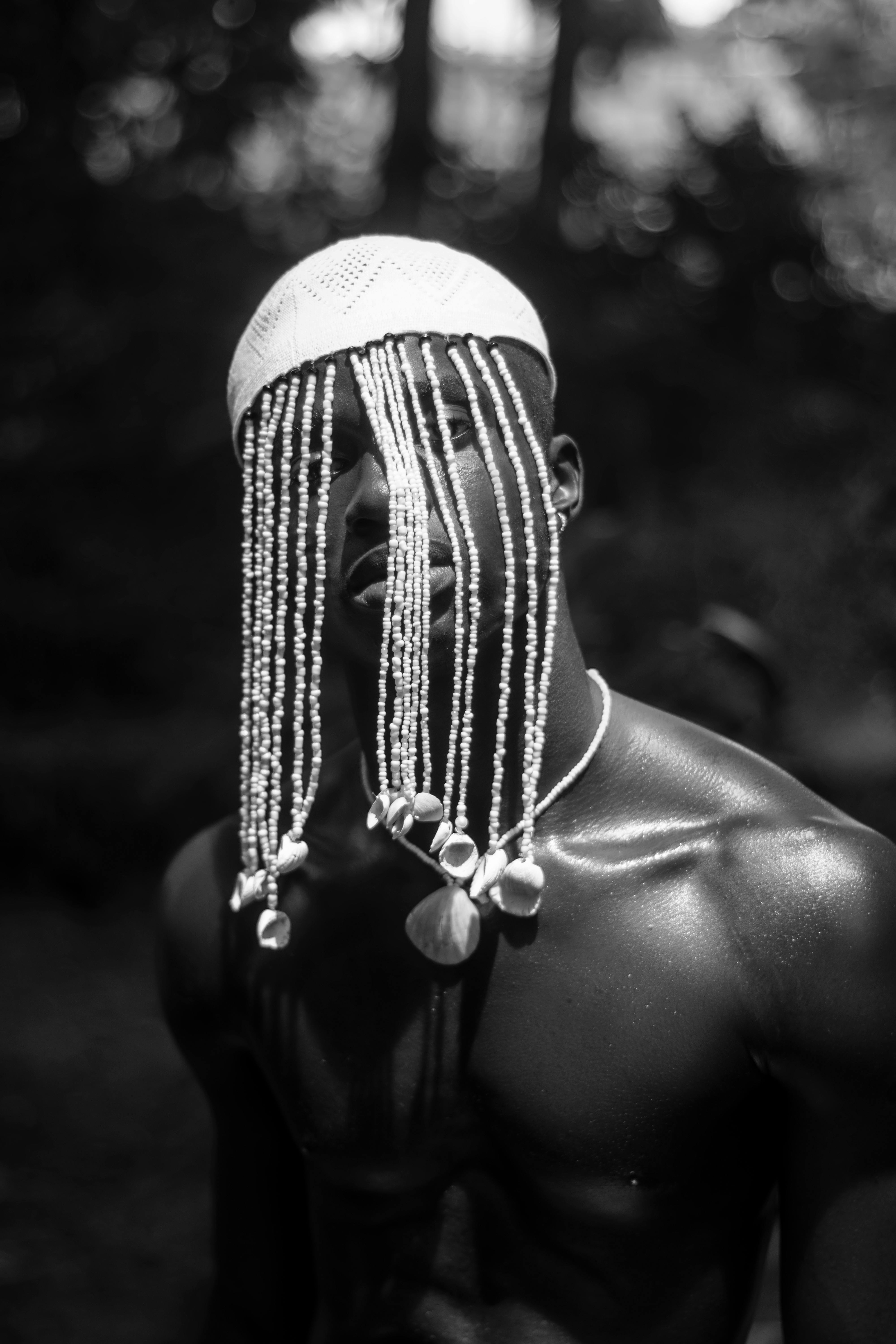 shirtless man with hat with seashells