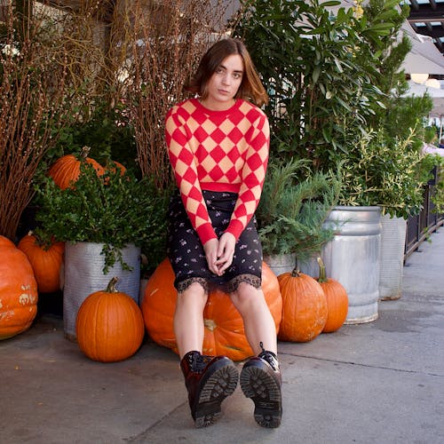 Young Woman Sitting on a Giant Pumpkin 
