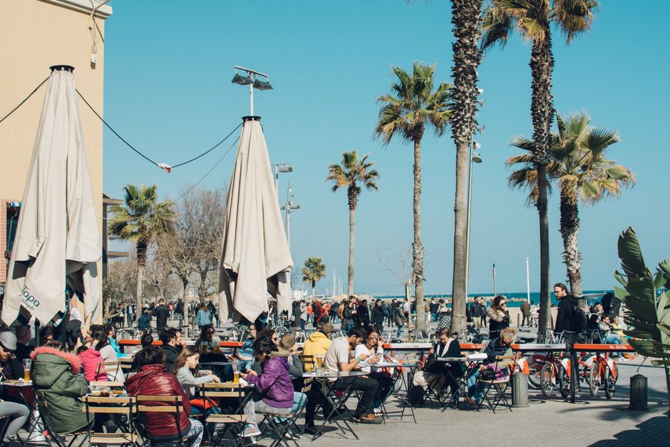 People enjoying free public Wi-Fi at an outdoor cafe in a Spanish city