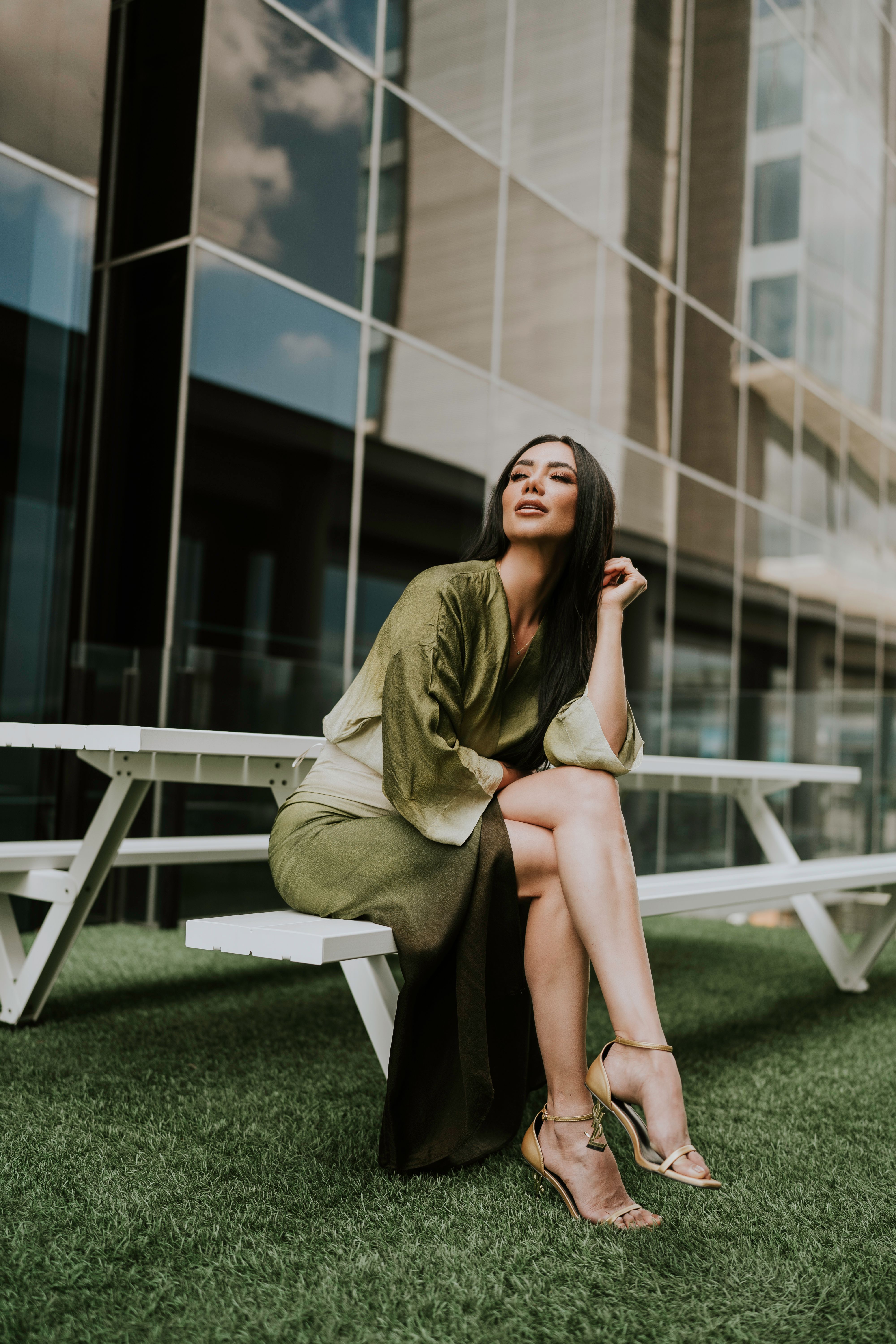 Woman in Green Dress Sitting on Wooden Bench while Looking Afar · Free ...