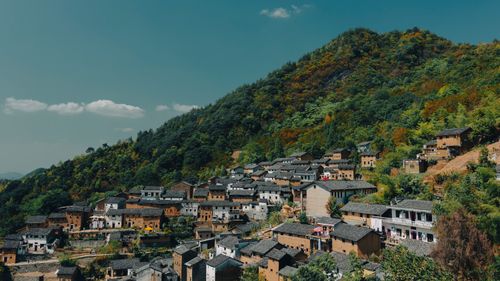 Free Scenic view of a traditional mountain village with lush green hills and classic brick houses. Stock Photo