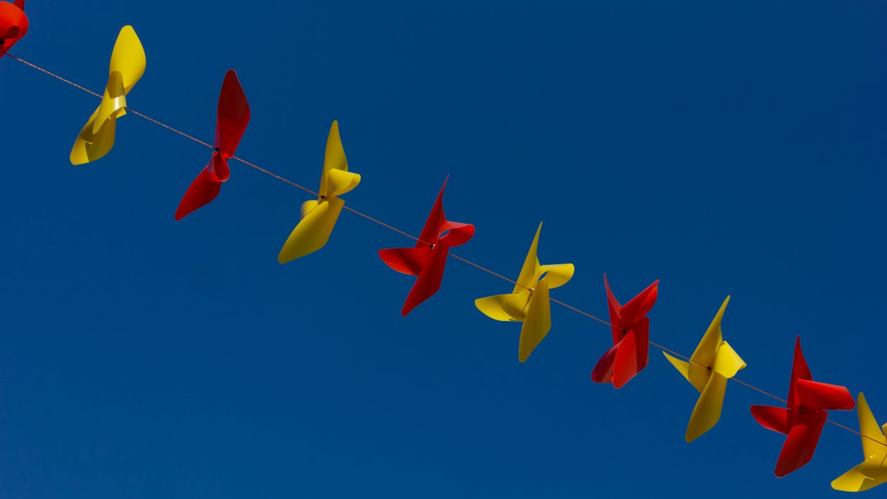 Photo of Red and Yellow Pinwheel on Stringline · Free Stock Photo