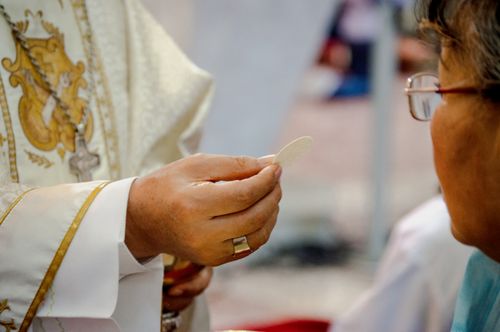 Free Close-up of a priest offering Holy Communion to a participant in Guayaquil, Ecuador. Stock Photo