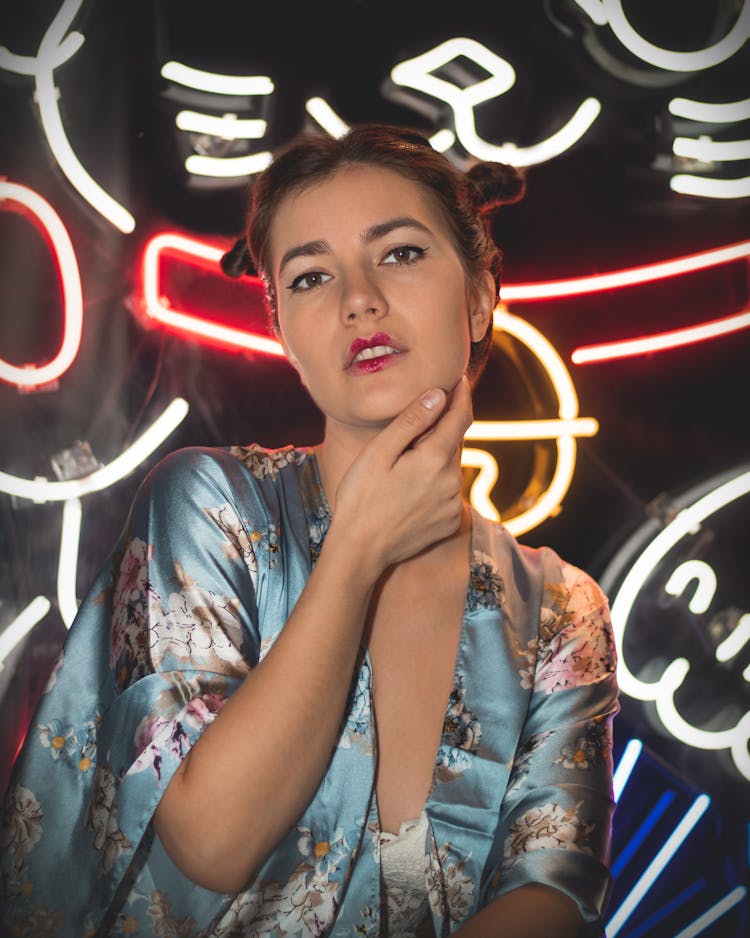 Woman In Silk Robe Standing In Front Of Neon Ligts