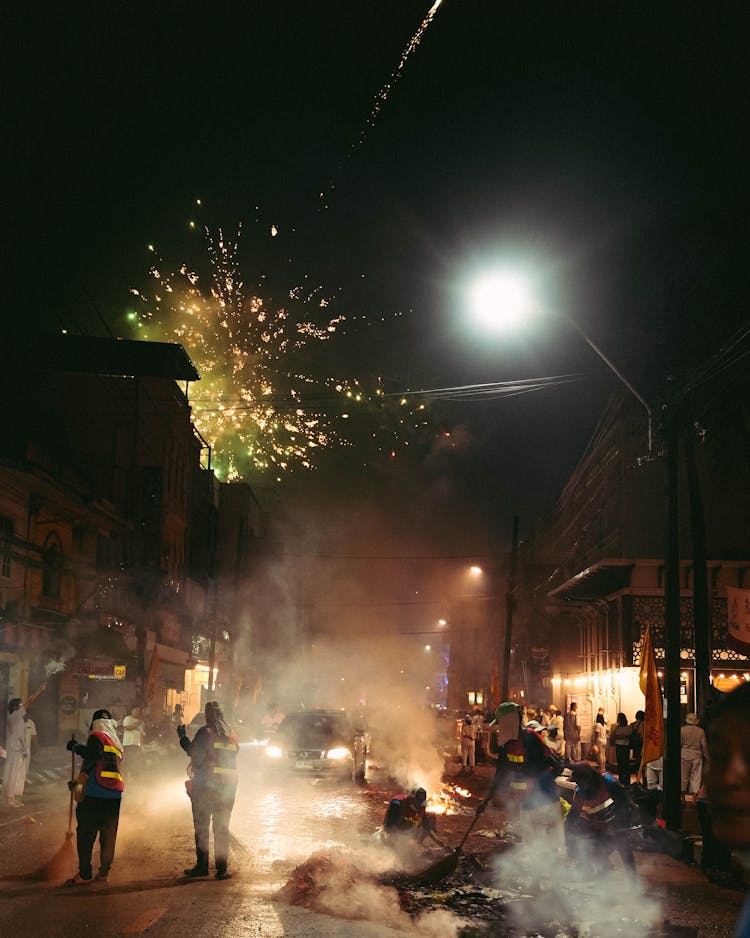 Men Sweeping Streets At Night