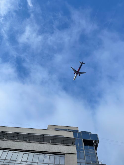 Free Low Angle Shot of an Airplane Flying in the Sky Stock Photo