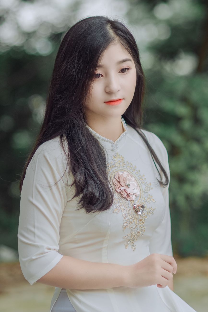 Stylish outdoor portrait of a young woman in traditional attire, showcasing elegance and beauty.