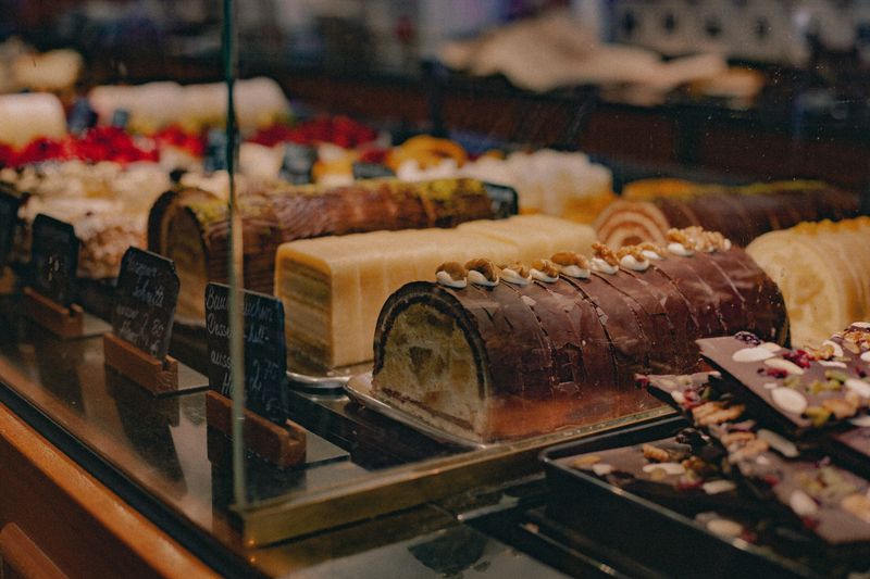 A tempting assortment of pastries and cakes displayed in a bakery shop window.