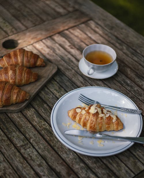 Free Croissants and Tea on Wooden Table Stock Photo