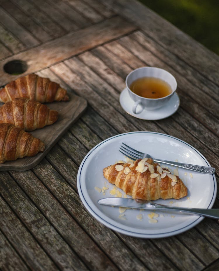Croissants And Tea On Wooden Table