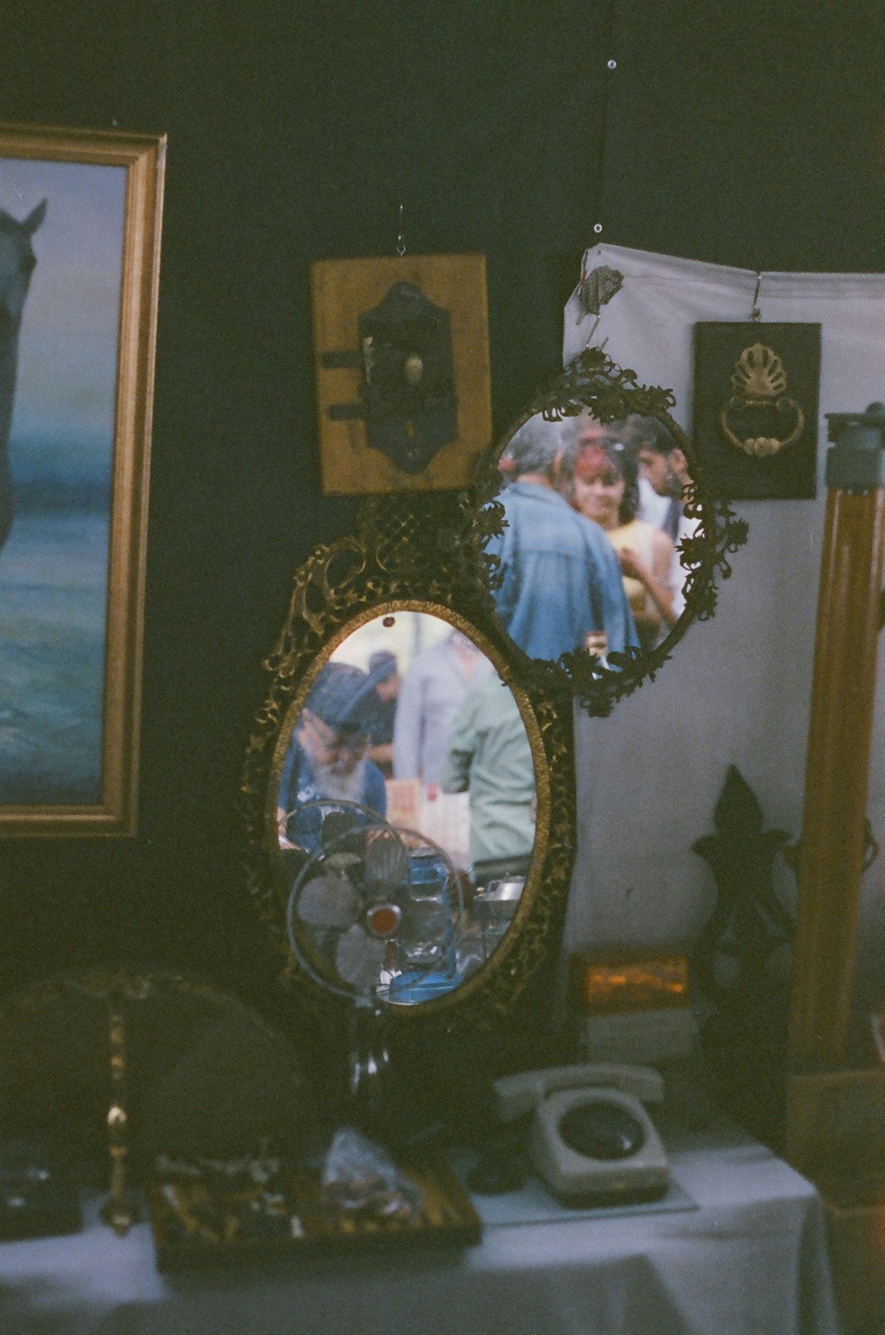 Ornate gilt vintage mirrors with foxed glass hanging on a stall at a flea market