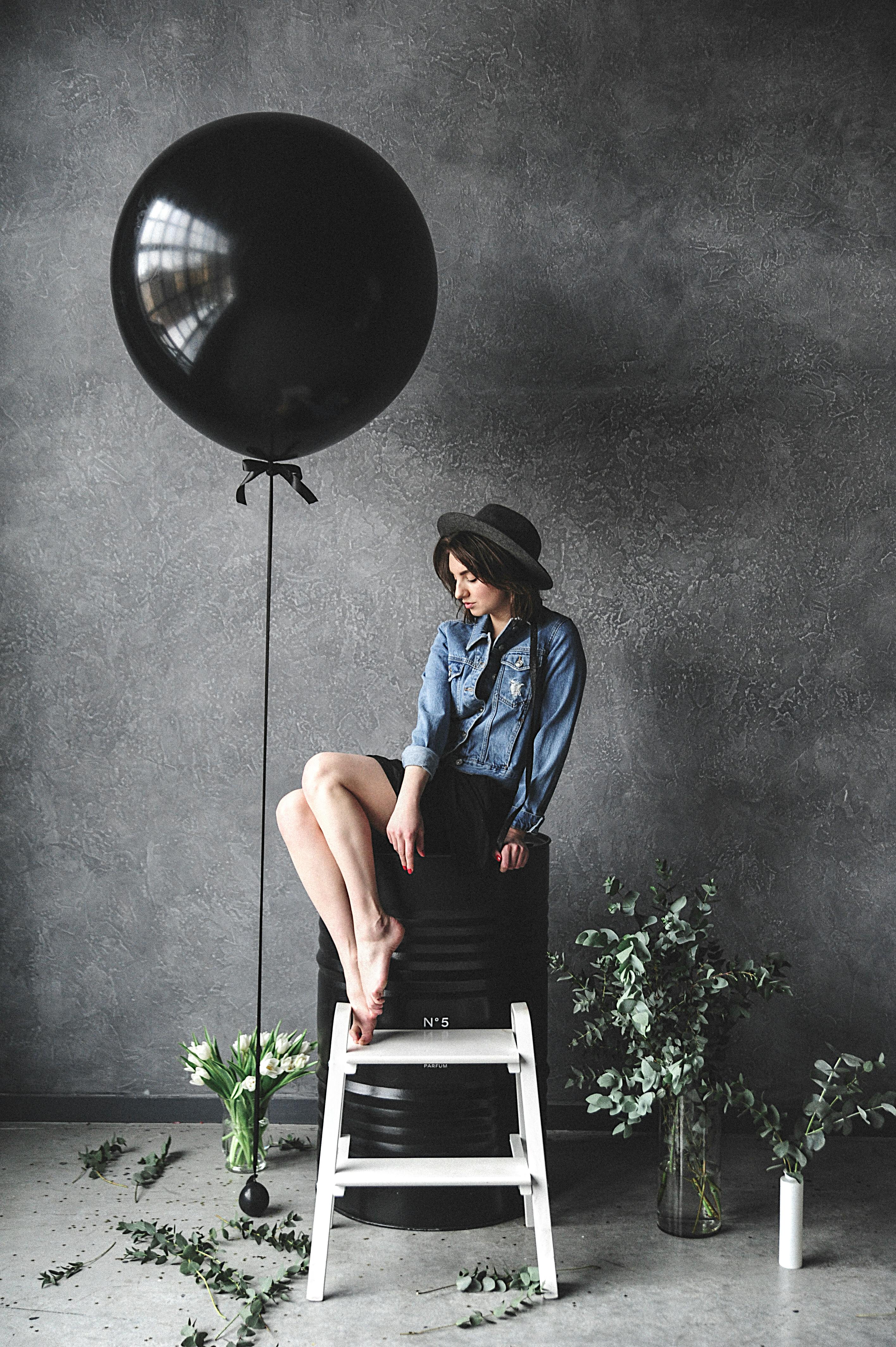Woman Sitting on Chair Beside Balloon