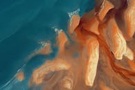 令人惊叹的航拍海岸线景观展示了充满活力的橙色沙滩与碧绿海洋的交汇