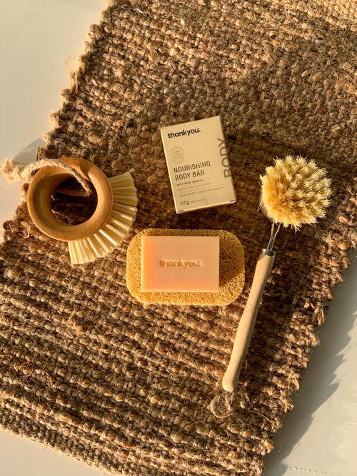 Free Eco-friendly hygiene products featuring a bar soap and brushes on a woven rug. Stock Photo