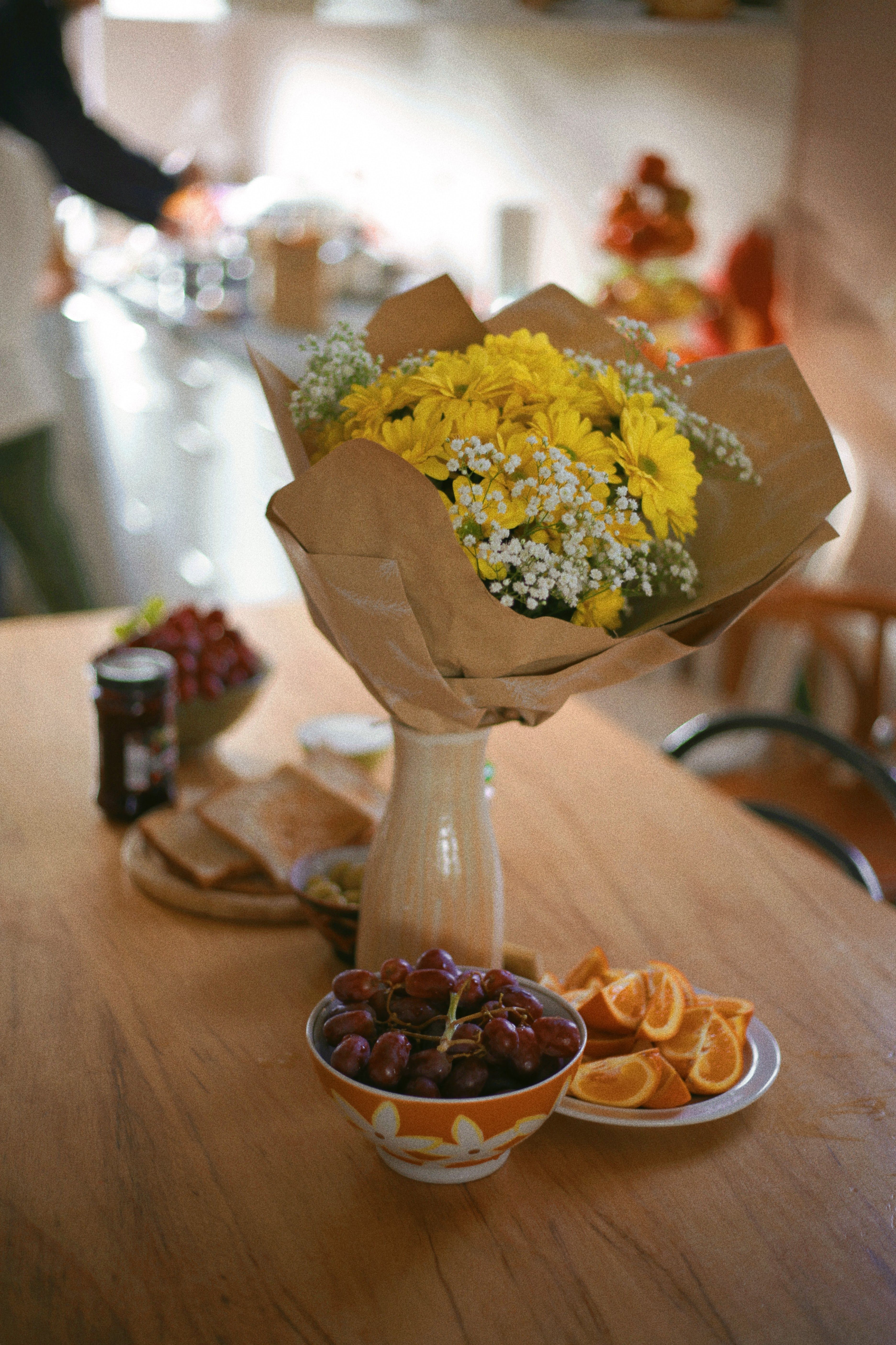 A vibrant bouquet of yellow flowers in a vase on a cozy kitchen table.