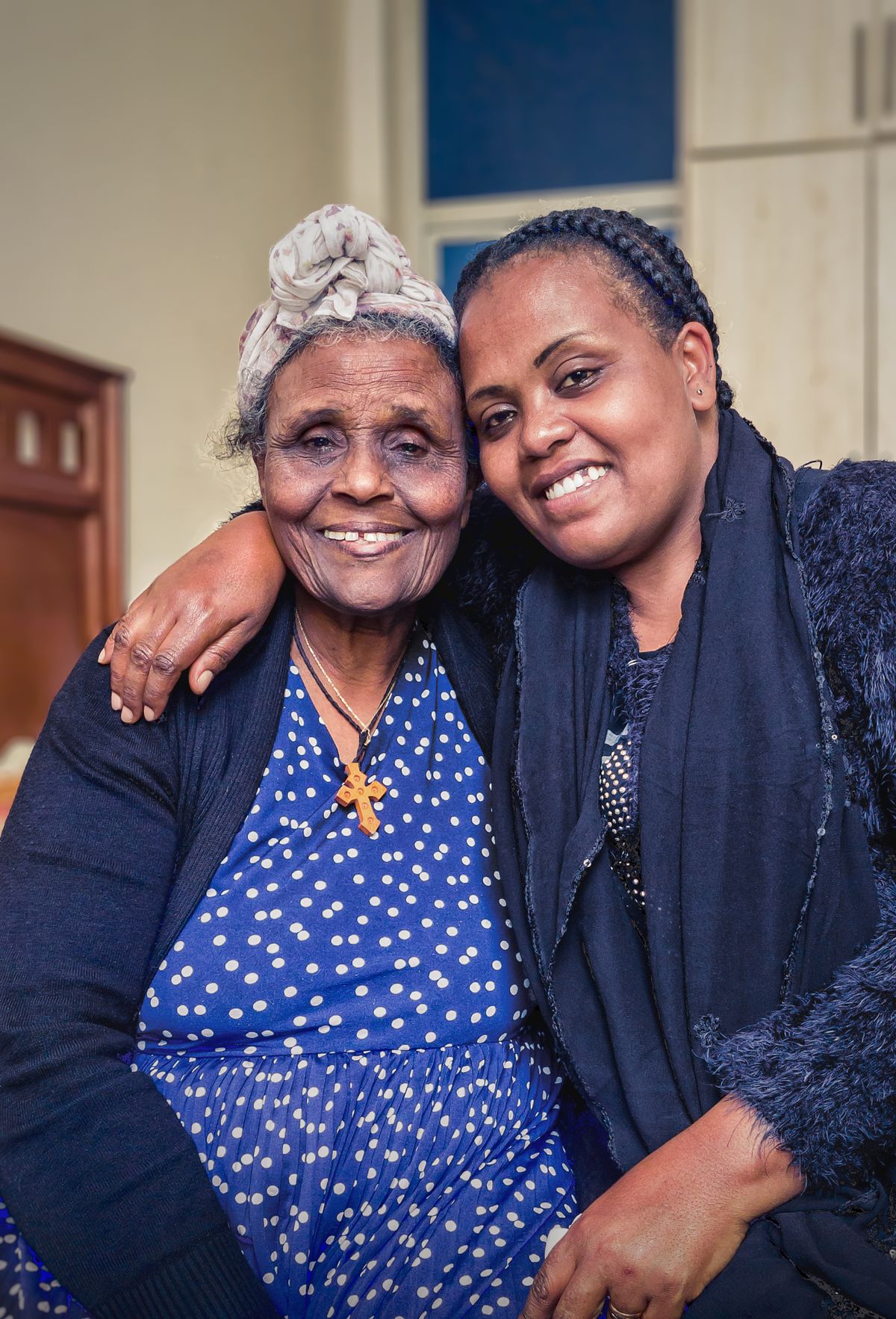 Daughter hugging her elderly mother at home