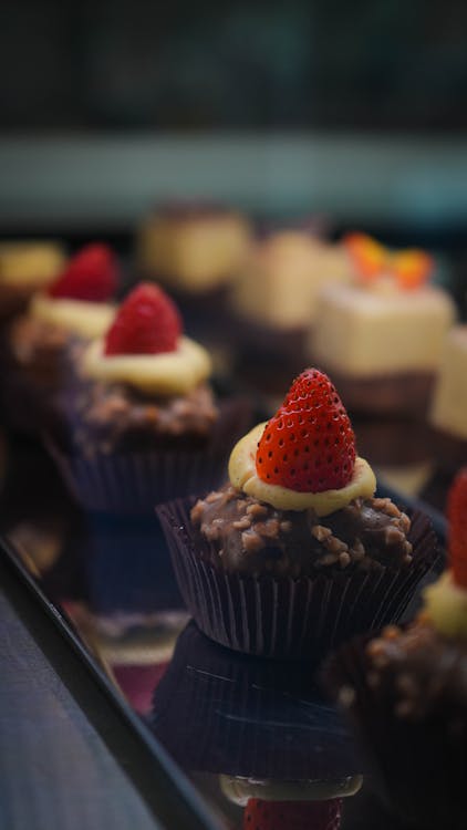 Close-up of Chocolate Balls with Cream and Strawberries on Top 