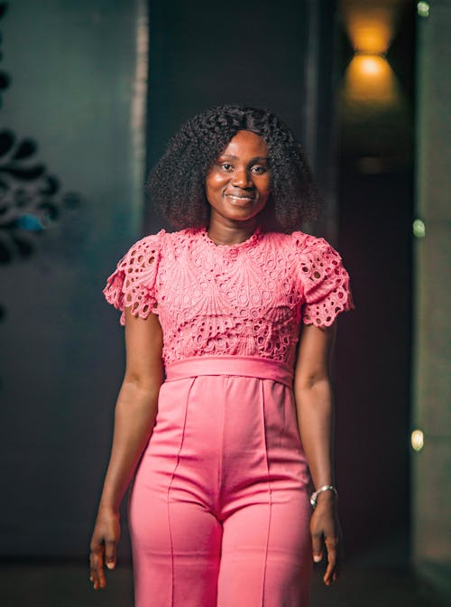 Woman in a Pink Openwork Blouse with High-waisted Trousers