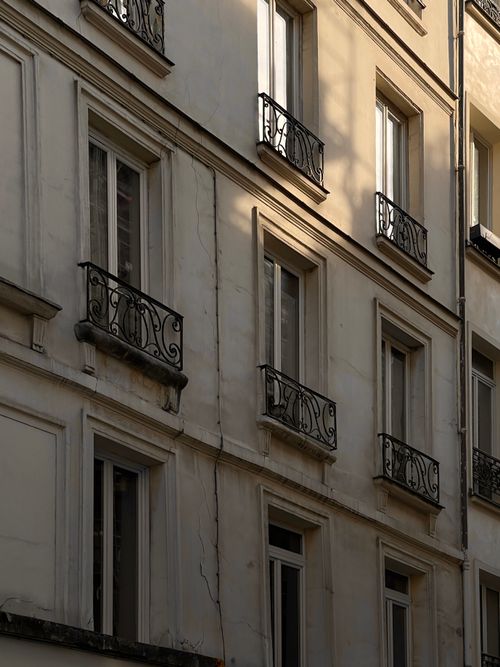 Free Charming urban facade showcasing classic architectural design with ornate iron balconies. Stock Photo