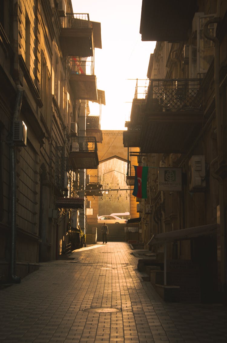 Back Lit Sepia Toned Photograph Of An Empty City Street With Balconies