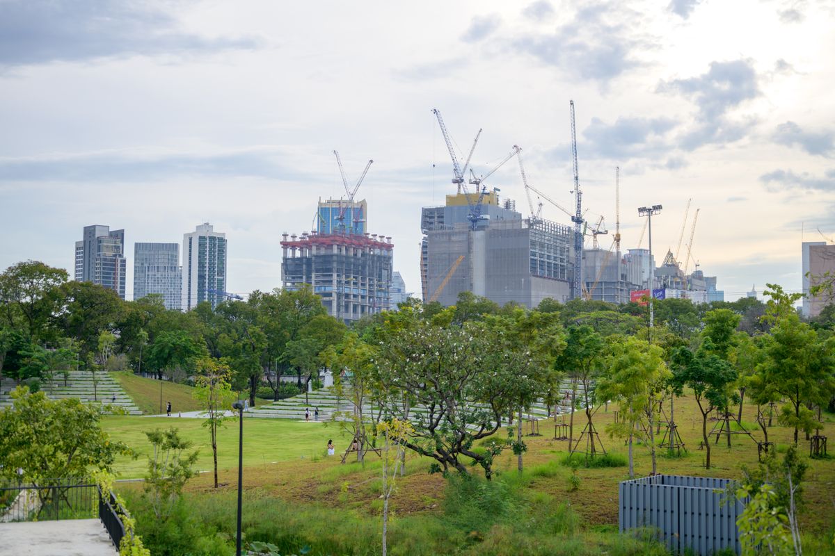 Real Estate Growth, Investor Confidence And Sustainable Construction Modern city buildings under construction beside landscaped green space representing real estate growth, investor confidence and sustainable development