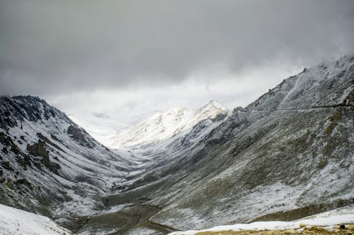 Snow-Covered Mountains under the Cloudy Sky