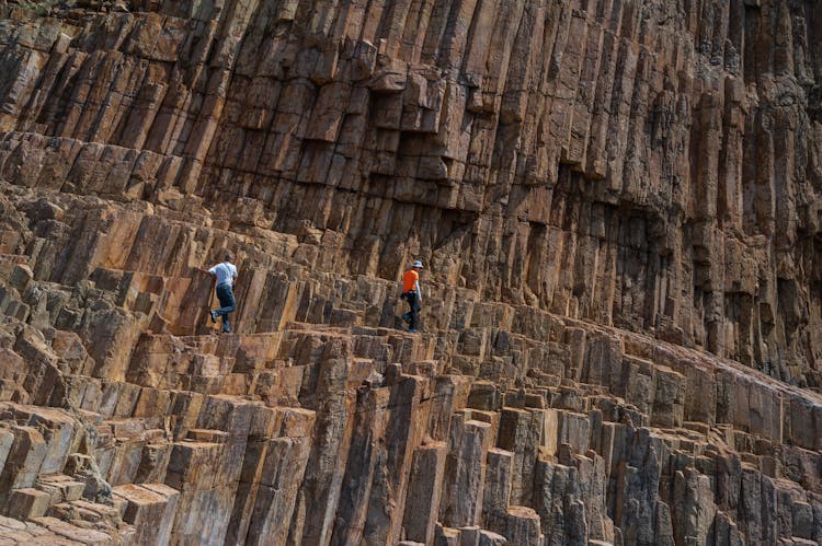 People Walking On Large Hexagonal Columns Of Volcanic Rock