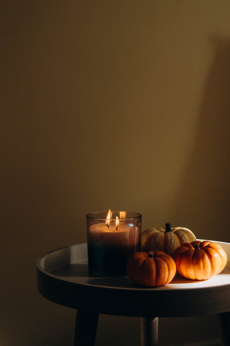 Pumpkins And A Candle On A Table