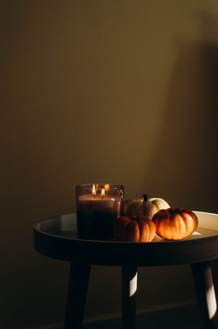 Pumpkins And A Candle On A Table