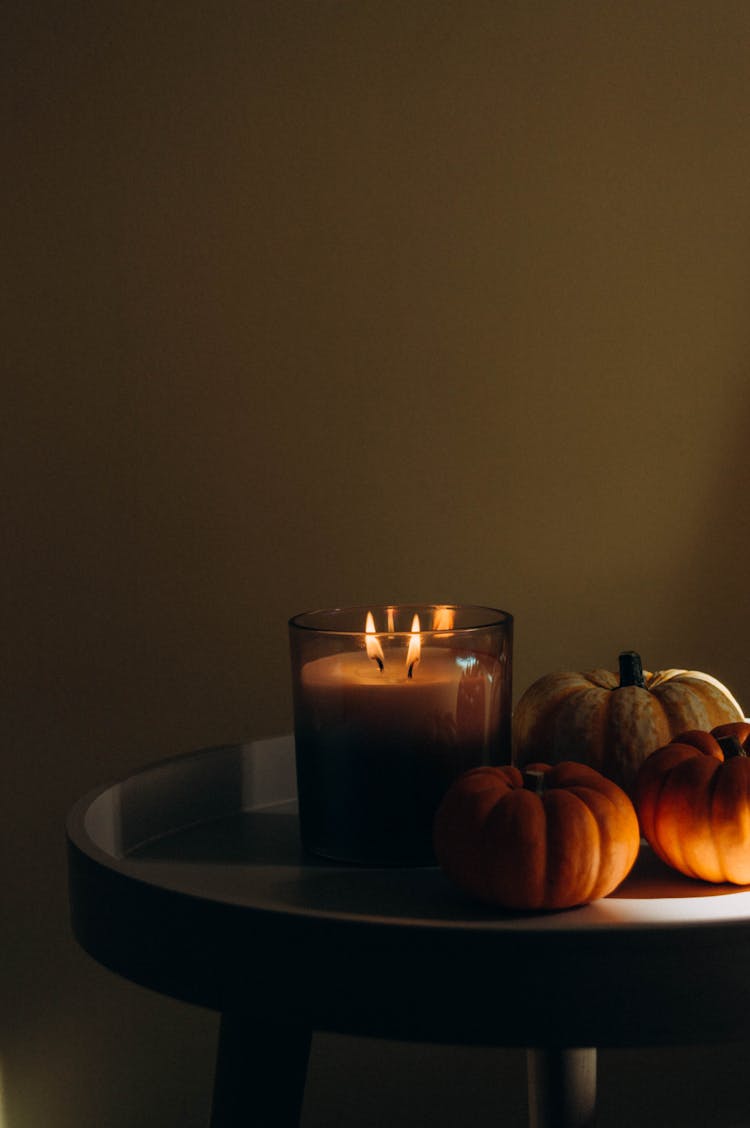 Pumpkins And A Candle On A Table