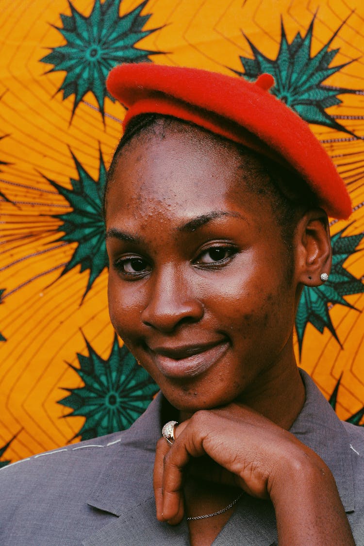 Portrait Of A Woman Wearing Red Beret Against Yellow And Green Pattern