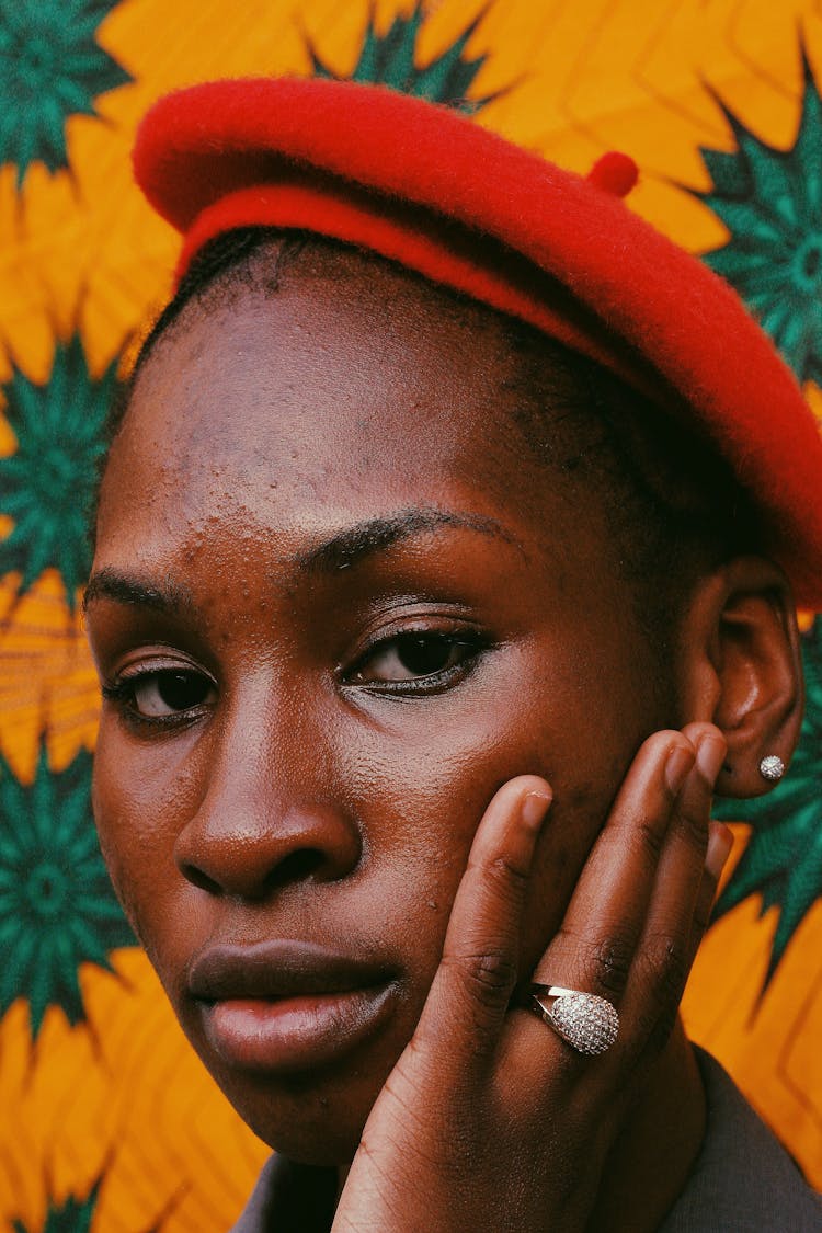 Portrait Of A Woman Wearing Red Beret Against Yellow And Green Pattern