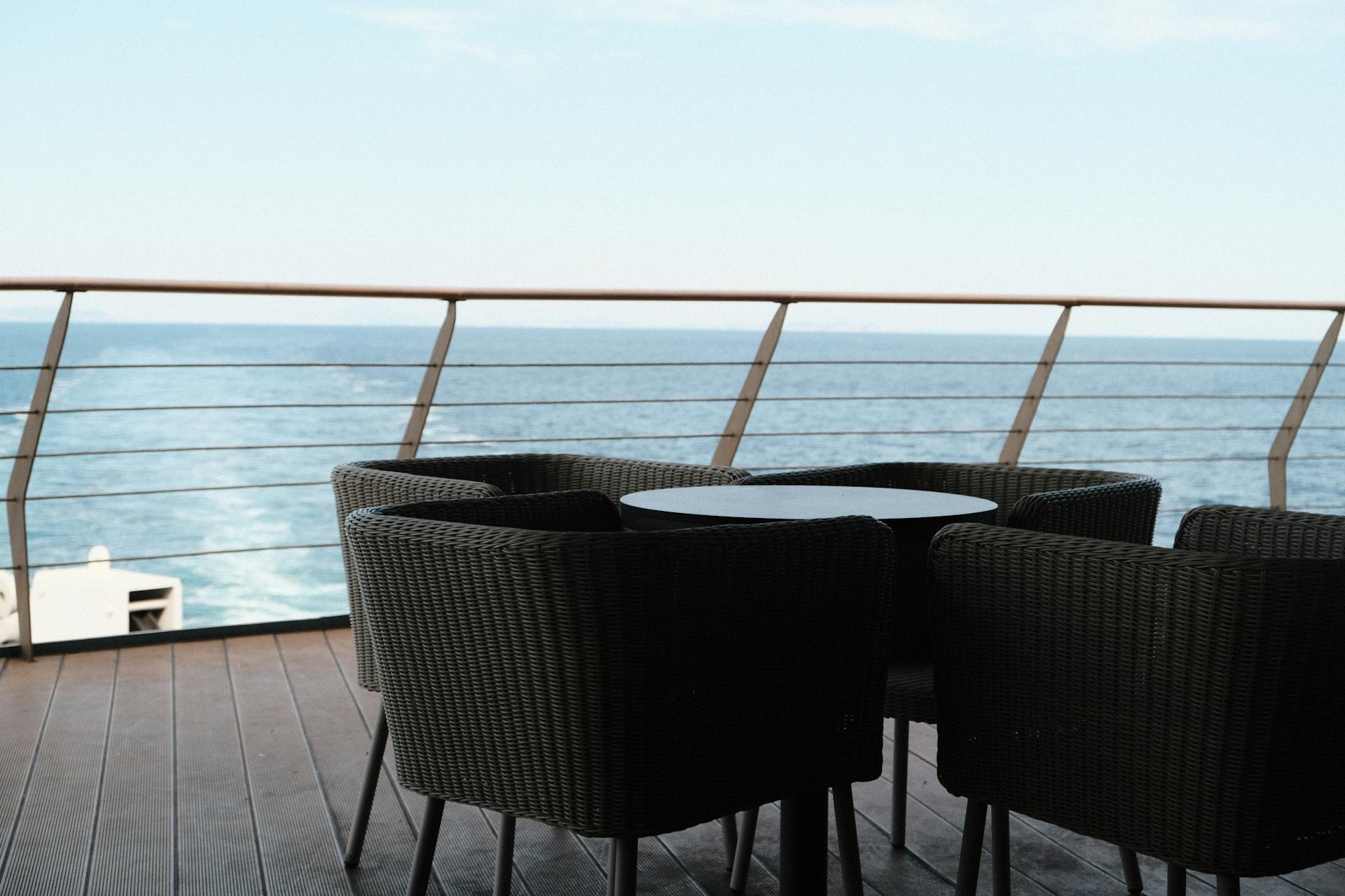 Elegant outdoor seating area on a cruise ship deck overlooking the ocean.