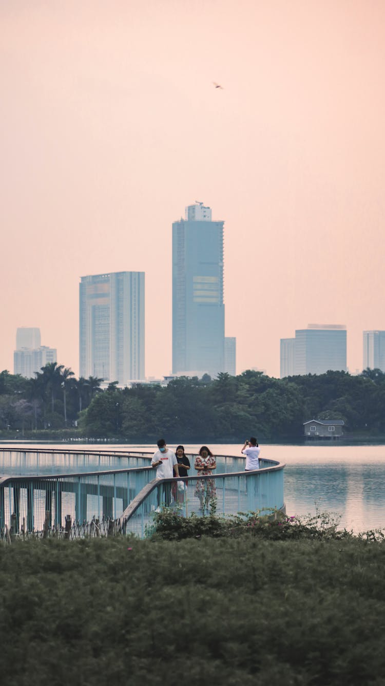 People On Promenade In City At Dusk