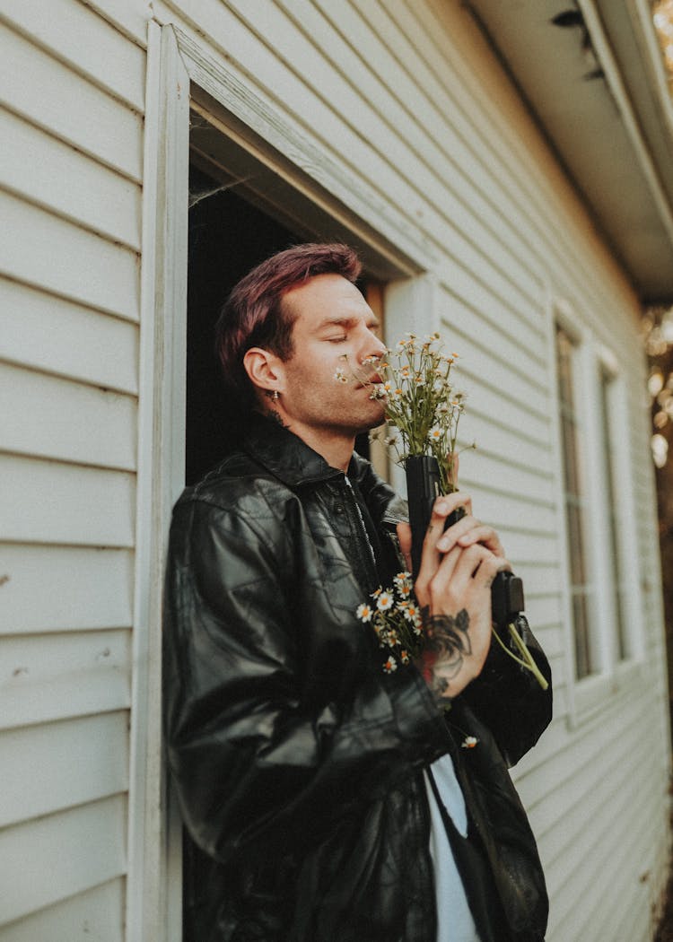 Man In Leather Jacket With Flowers In Gun