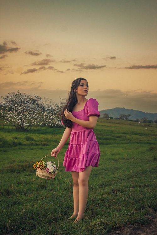 A Woman in Pink Dress Standing on the Grass Field · Free Stock Photo