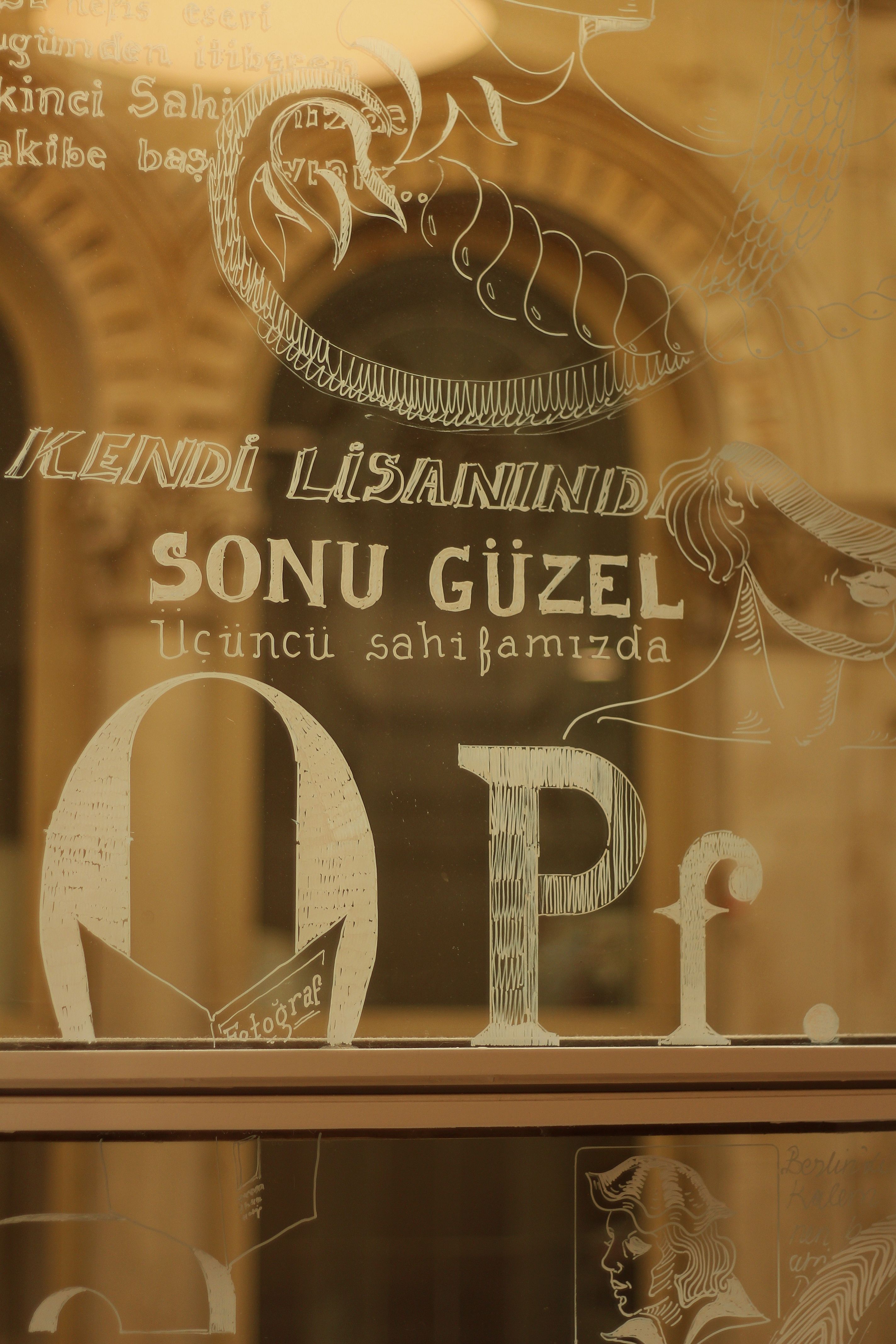 Artistic text and designs on a glass panel reflecting stylistic elegance.
