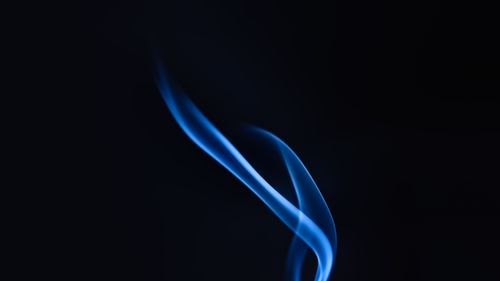 Free Elegant wavy blue smoke on a dark background, creating a mysterious and artistic effect. Stock Photo