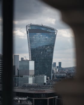 View of the Walkie Talkie skyscraper in London reflecting the skyline under cloudy skies.