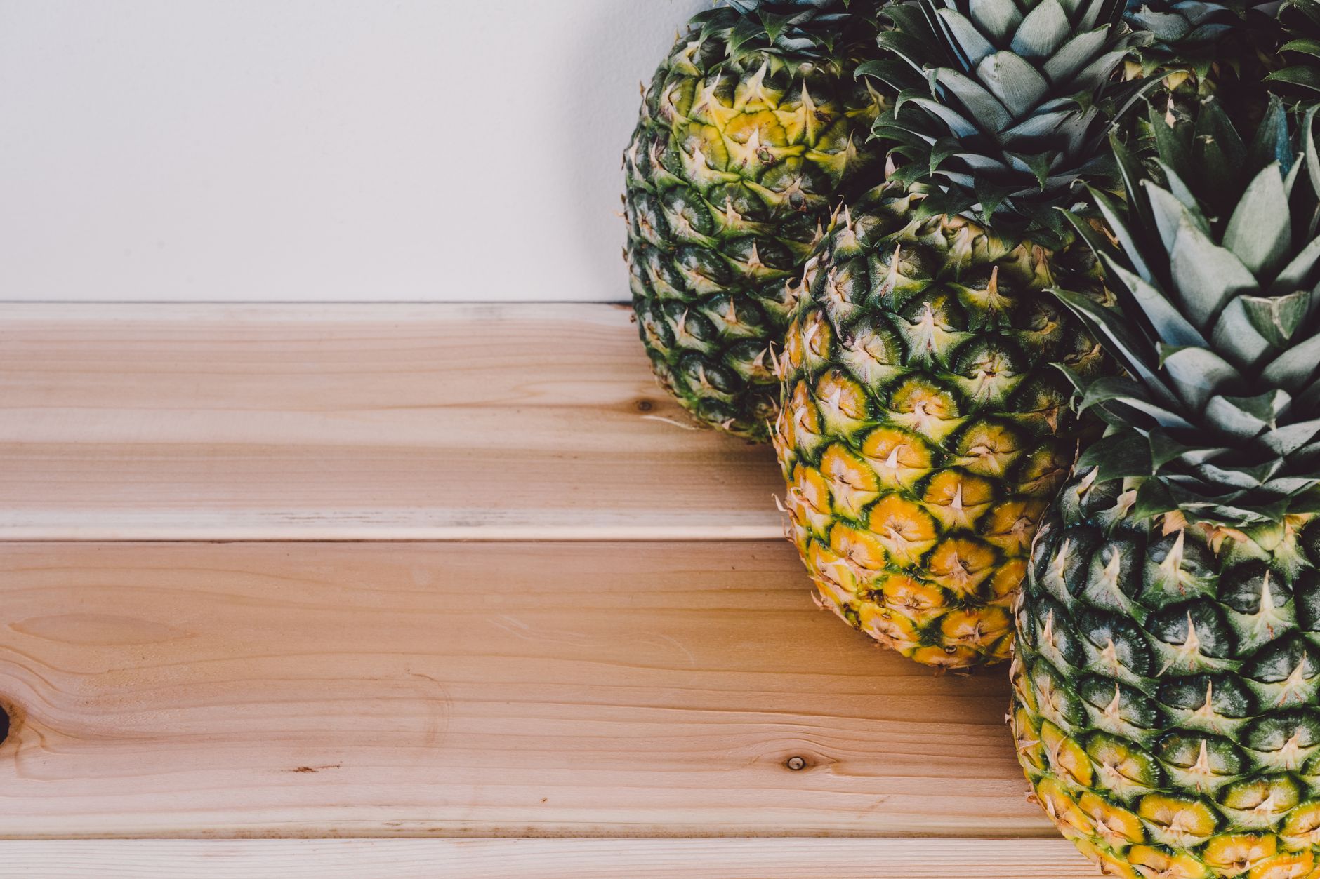 Bromelain spike protein benefits — Close-up of fresh pineapples on a wooden table, showcasing tropical fruit textures.