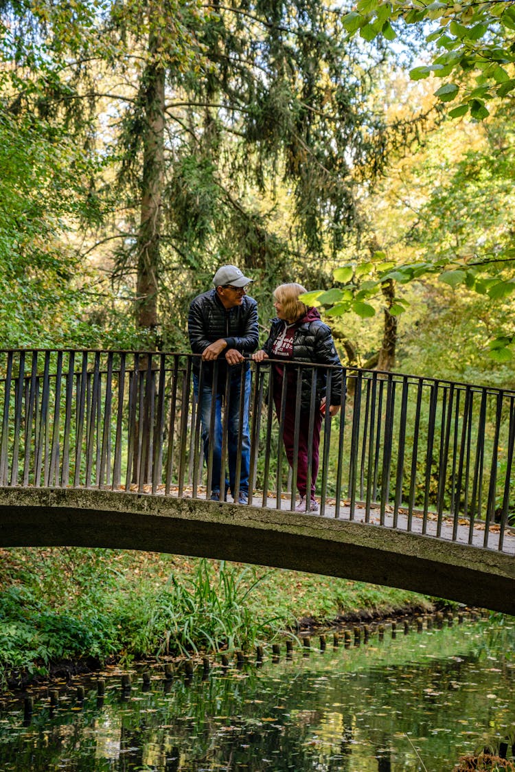 Man And Woman Standing On Bridge And Talking