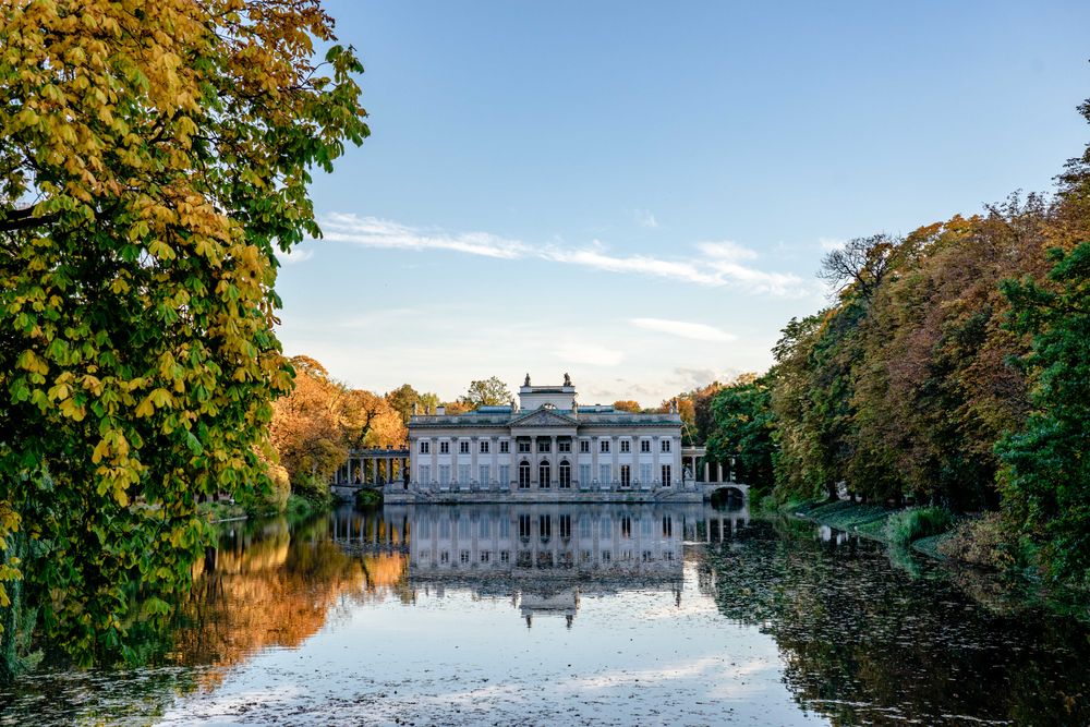 Palatul de pe Insulă din parcul Łazienki, oglindit în lac, înconjurat de culori de toamnă