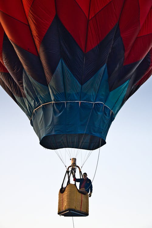Man Riding Blue and Red Hot Air Balloon during Day
