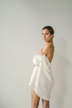 An elegant portrait of a woman draped in white, showcasing timeless beauty and grace.