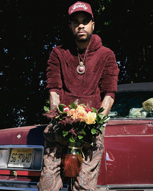 Man With Bouquet Leaning on Car