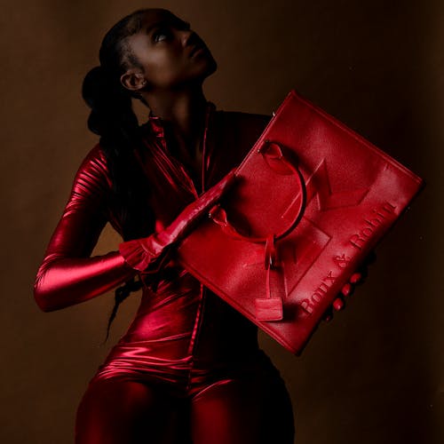 A Woman in a Red Jumpsuit Holding a Red Leather Handbag